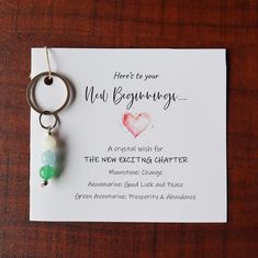 a card with a keychain attached to it that says, here's to your new beginnings