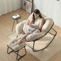 a woman sitting in a chair on top of a floor next to a coffee table