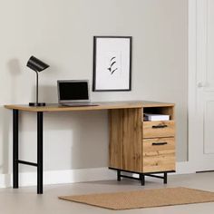 a desk with a laptop on it in front of a door and a rug next to it