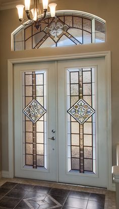 the front door is decorated with stained glass and has two sidelights on each side