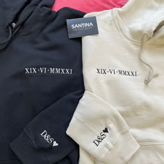 three sweatshirts sitting next to each other on a table