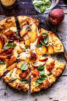 a pizza with peaches and basil on it