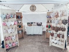 an outdoor market with many items for sale on the tables and in front of it is a white tent