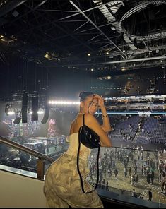 a woman standing in front of a crowd at a stadium