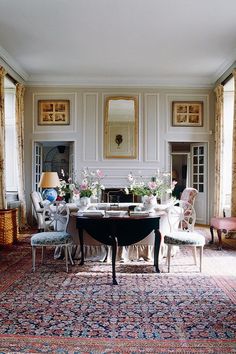 a dining room filled with lots of furniture next to a fire place in a living room