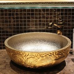 a golden bowl shaped sink sitting on top of a counter