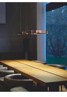 a long wooden table sitting in front of a window