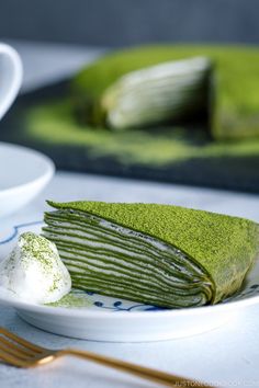 there is a plate with green cake on it and a fork next to the plate