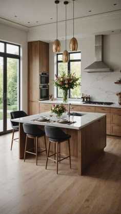 a kitchen with wooden cabinets and marble counter tops, along with two black bar stools