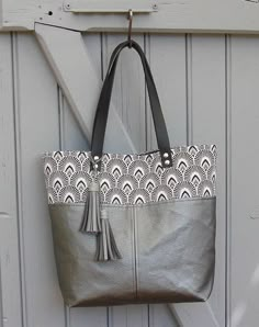 a purse hanging on the side of a white door with a tasseled handle