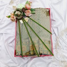 an arrangement of flowers and ribbons on a white bed sheet with lace in the middle