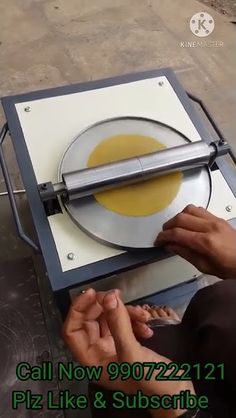 a person is using a machine to cut something out of a piece of paper that has been placed on top of it