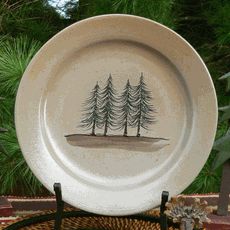 a white plate sitting on top of a table next to a basket filled with pine trees