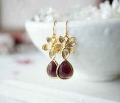 "These feminine and delicate earrings feature gorgeous faceted burgundy colored crystals and matte gold plated flowers (silver version also available). These earrings are light weight and can be made as clip on earrings for non-pierced ears. The crystals are available in more than 10 colors. Measurements & Details: - Total length (including ear wires): approx. 1.6\" (42mm) - Flower: matte gold or matte rhodium silver plated brass - Ear wires: nickel and lead free gold or rhodium silver plate Powder Blue Wedding, Burgundy Earrings, Winter Earrings, Wedding Gifts For Bridesmaids, Red Earrings, Burgundy Wedding, Wedding Bridesmaid, Gold Flower, Delicate Earrings