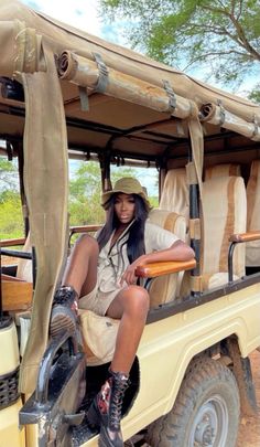 a woman sitting in the back of a safari vehicle