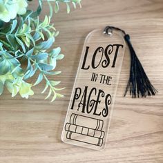 a bookmark with the words lost in the pages on it next to a plant