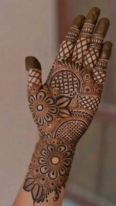 a woman's hand with henna tattoos on it