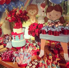 a table topped with lots of cakes and cupcakes