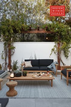 an outdoor living area with couches, tables and potted plants