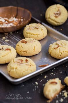 freshly baked cookies on a cookie sheet with a wooden bowl and spoon in the background