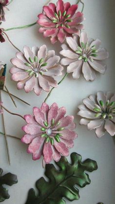 some pink and green flowers on a white surface