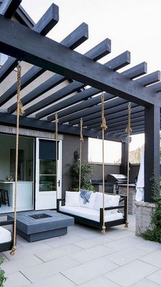 a white couch sitting on top of a patio next to a wooden pergoline