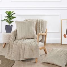 a chair with a blanket on it next to a potted plant