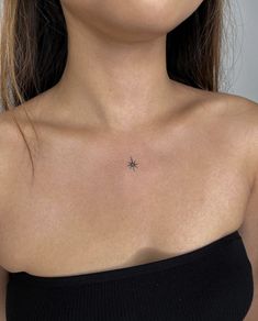 a woman's chest with a small star tattoo on the left side of her chest