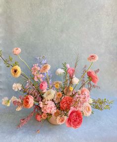 a vase filled with lots of different colored flowers