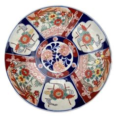 a decorative plate with flowers and birds on the rim, painted in red, white, blue and orange