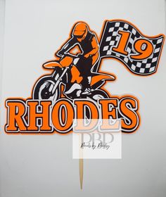 an orange and black sticker on the side of a white wall that says rhodes