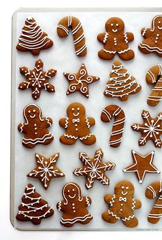 many different types of decorated ginger cookies on a white surface with icing and decorations