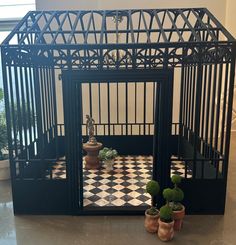 two potted plants sit in front of a black and white checkered tile floor