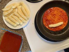 two pans filled with food sitting on top of a stove