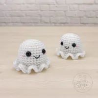 two crocheted octopus figurines sitting next to each other on a table