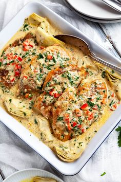 a white plate topped with pasta and meat covered in sauce next to two plates of food