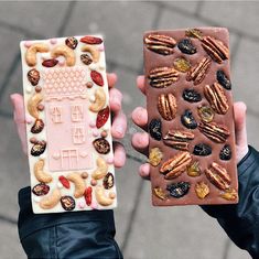 two people holding up different types of food and one is holding a piece of chocolate