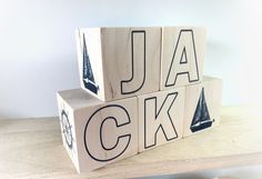 three wooden blocks that spell out the word jack on top of each other with sailboats