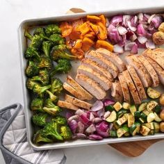 a pan filled with chicken, broccoli and other vegetables