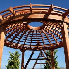 a wooden gazebo sitting on top of a lush green field