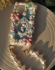 a white plate topped with a cell phone covered in pearls