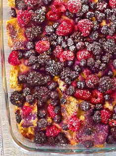 a casserole dish with berries and powdered sugar on the top is ready to be eaten