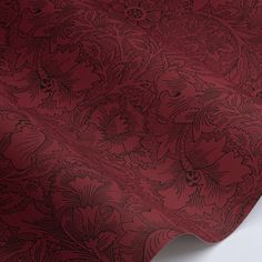 a red and black wallpaper with an intricate design on the back side of it