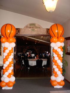 an indoor basketball court decorated with orange and white roped posts for the entrance to a home