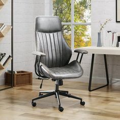 an office chair sitting on top of a hard wood floor in front of a window