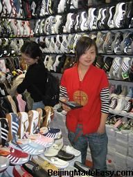 a woman standing in front of a display of shoes