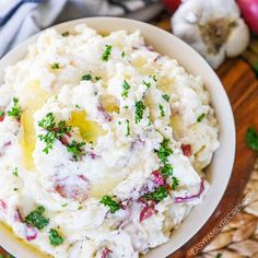 a white bowl filled with mashed potatoes and parsley