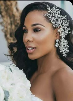 a woman in a wedding dress holding a bouquet and wearing a bridal hair comb