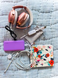 headphones, wallet and other items laid out on a bed