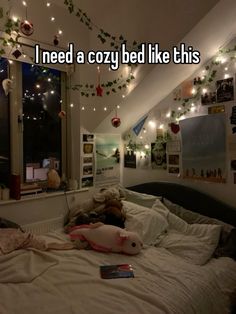 a bed in a room with lights strung from the ceiling and stuffed animals on it